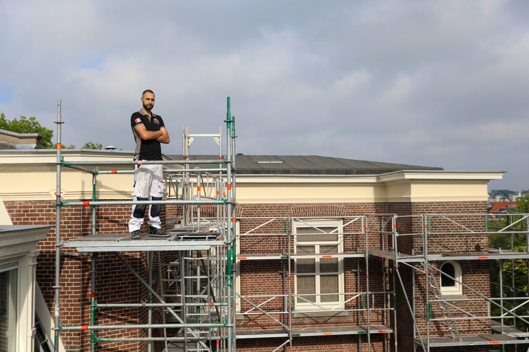 Schilder van AMG op de steiger boven een Amsterdams pand
